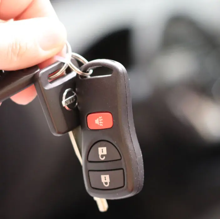 Hand holding a car key with remote